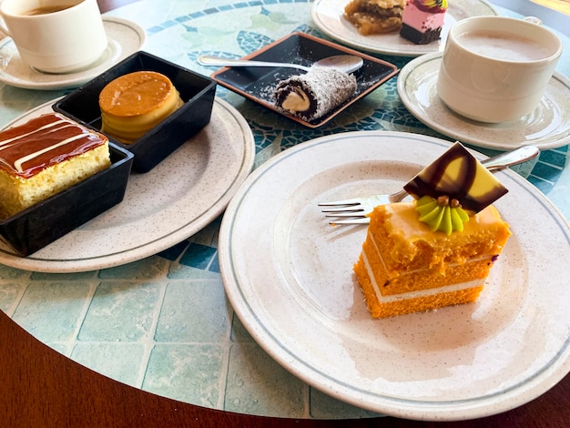 Various colored cakes on plates. Sweet desserts. Studio Photo