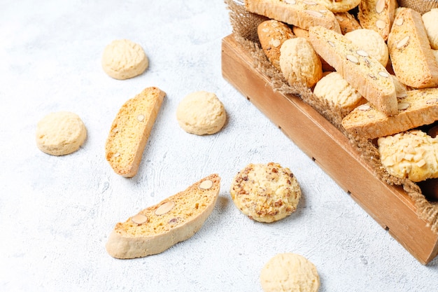 Various cookies in a wooden tray on gray