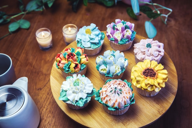 Various cupcakes decorated with colorful flower icing on wooden table floral bouquet wedding cake hi