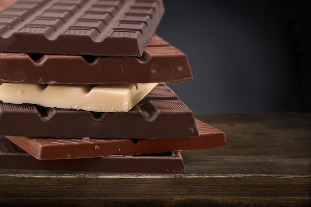 Various delicious chocolate stack on wooden desk