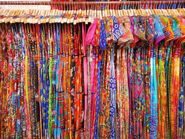 Various Designs of Colorful Women's Patterned Clothes Hanging on Rack