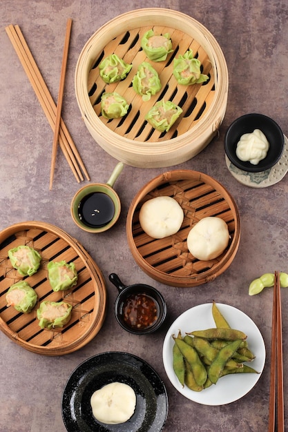 Various Flat Lay Chinese Food, Dim Sum (Dimsum) on Bamboo Steamer Above Concrete Brown Top.