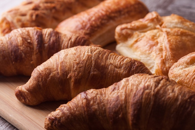 Various freshly baked pastries on wooden cutting board. Tasty snack.