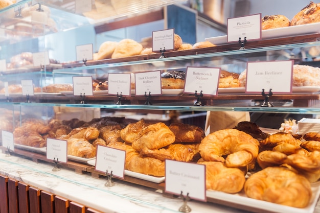 Various freshly and warm baked bread rolls on the shelf and ready to sell. Homemade by art