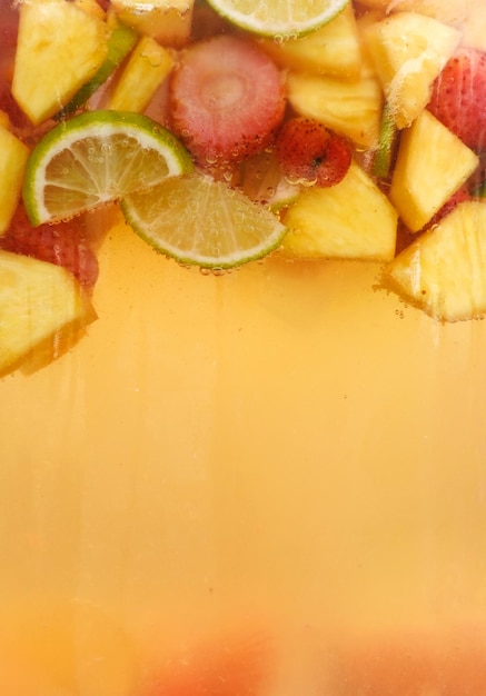 Various fruits in a jar with compote or lemonade Vertical photo