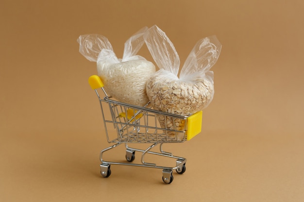 Various groats in packages in grocery cart. Rice and oatmeal