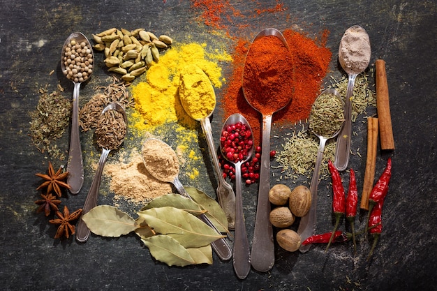 Various herbs and spices for cooking on dark, top view