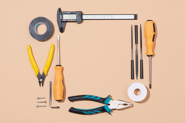 Photo various household tools on beige background labor day concept