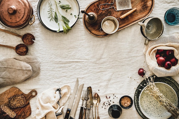 Photo various kitchen utensils and tablewear over linen tablecloth copy space