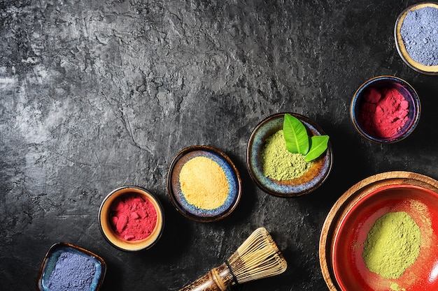 Various matcha tea powders on a dark concrete background  