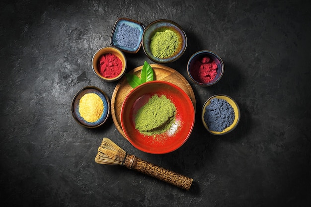 Various matcha tea powders on a dark concrete