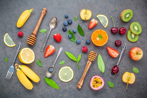 Various mixed fruits on dark stone background for sweets menu design.