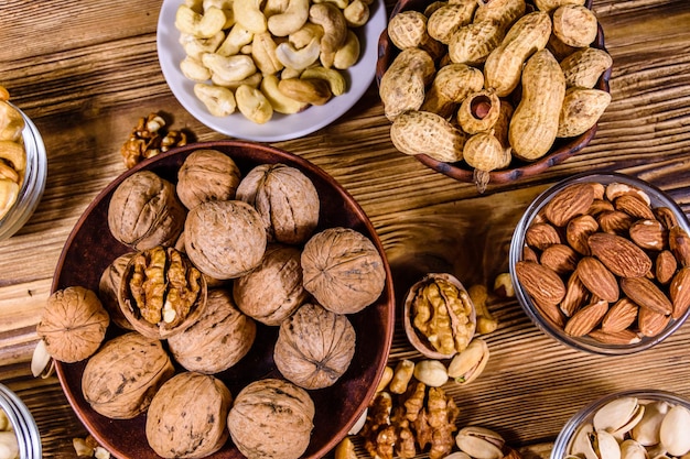 Various nuts almond cashew hazelnut pistachio walnut in bowls on a wooden table Vegetarian meal Healthy eating concept Top view