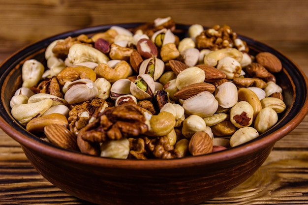 Various nuts almond cashew hazelnut pistachio walnut in ceramic plate on a wooden table Vegetarian meal Healthy eating concept