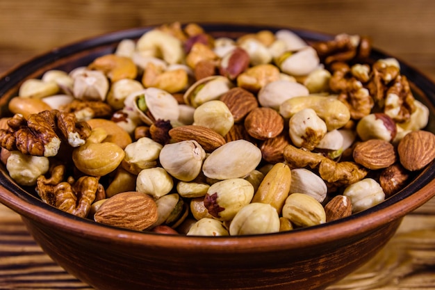 Various nuts almond cashew hazelnut pistachio walnut in ceramic plate on a wooden table Vegetarian meal Healthy eating concept