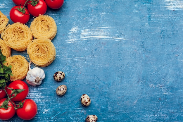 Various pasta on blue background. Cooking concept. Top view