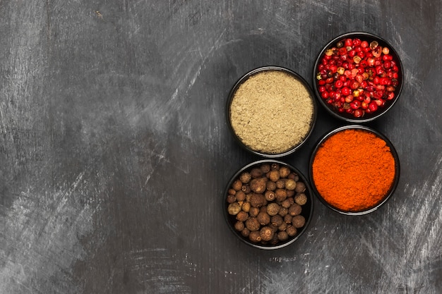 Various pepper on a black background. Top view, copy space. Food background