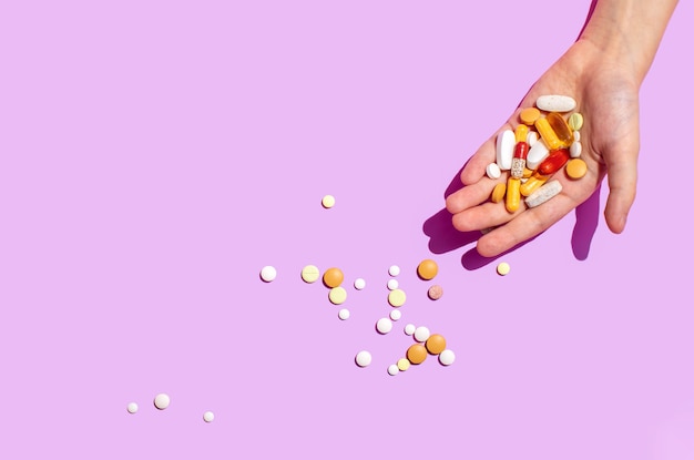 Various pills lying in a hand, overhead view, copy space for a text