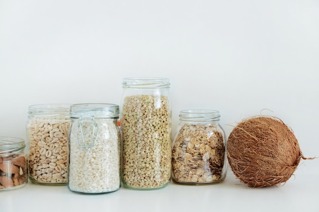 Various raw cereals grains in glass jars concept of zero waste food storage in the kitchen