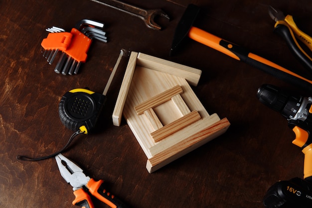 Various repair tools and model of house Repair tool kit on a wooden background