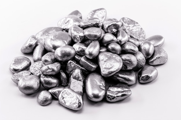 Various rough silver nuggets on black surface, texture of silvery stones.