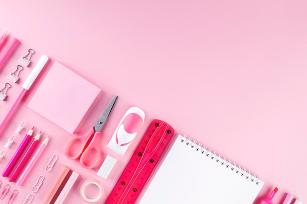 Various school office and painting supplies on pink background. space