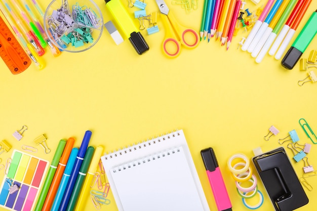 Various school office and painting supplies on yellow background. Back to school concept.