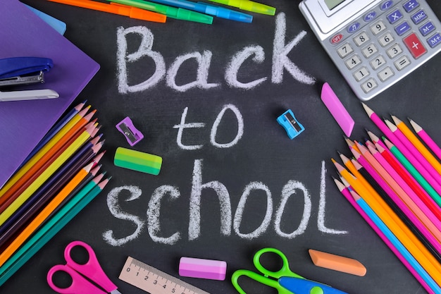 Various school supplies on a blackboard