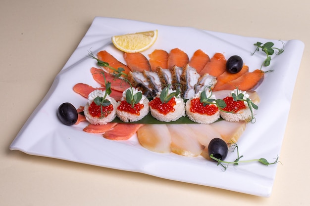 Various seafood on a white plate with lemon and greens Isolated on a white background