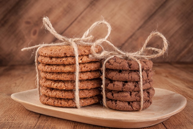 Various shortbread, oat cookies, chocolate chip biscuit on dark rustic wooden table.