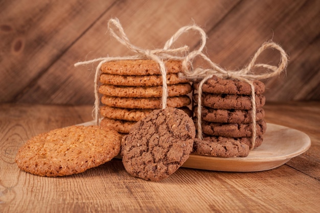 Various shortbread, oat cookies, chocolate chip biscuit on dark rustic wooden table.