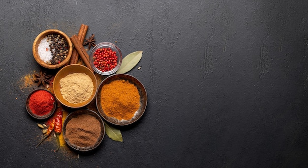 Various spices in bowls on stone table