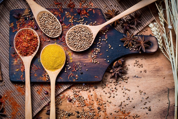 various spices and herbs in wooden spoon