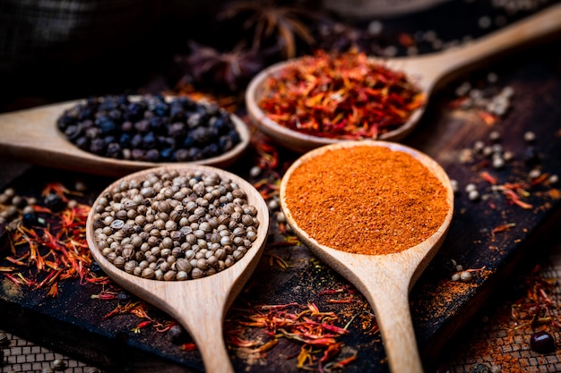 various spices and herbs in wooden spoon