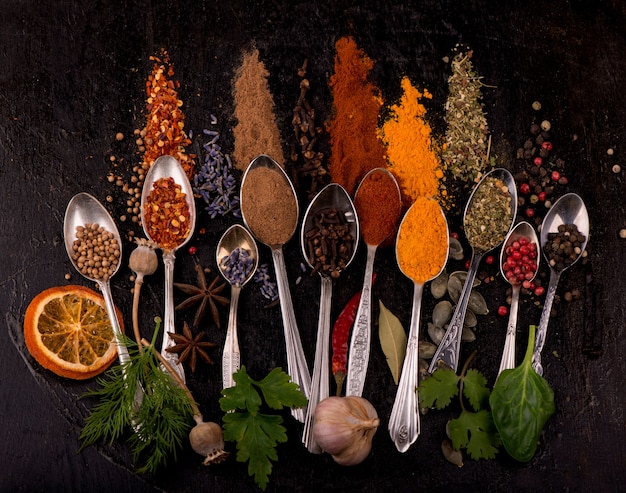 Various spices spoons on stone table. Top view with copy space.