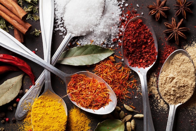 Various spices spoons on stone table