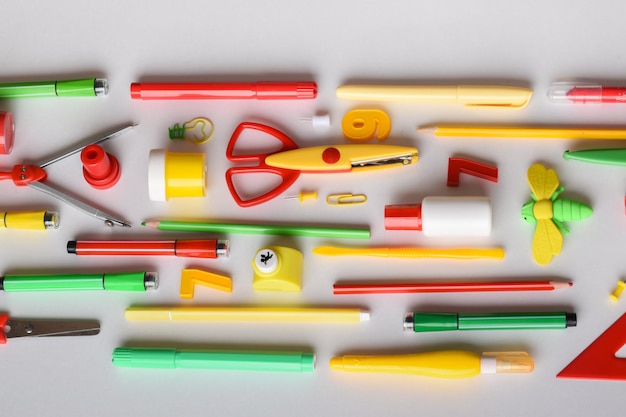 Various stationery of red yellow and green colors are in the center on a light background Back to school Space for copying Flat position top view