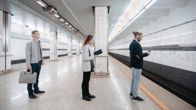 various subway passengers waiting for the arrival of the train