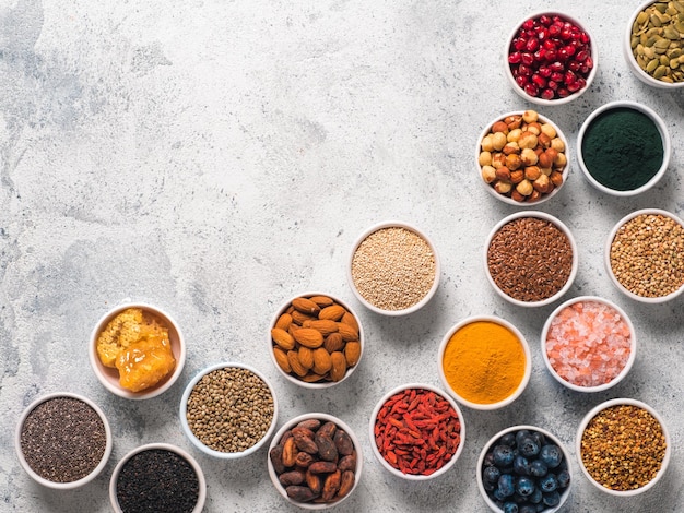 Various superfoods in bowl on gray background