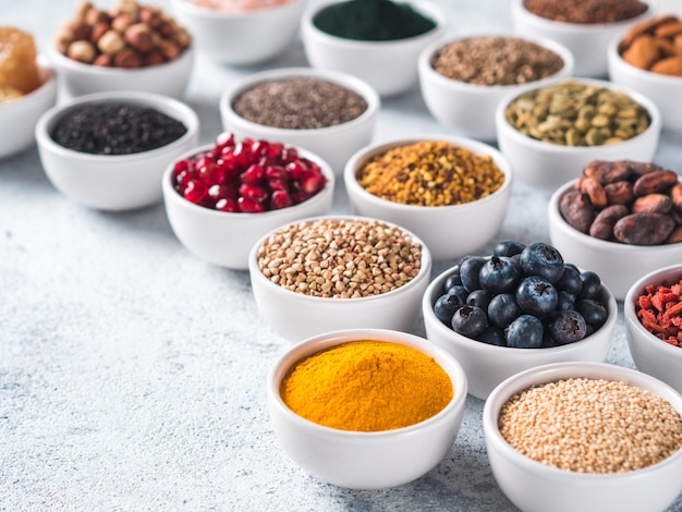 Various superfoods in bowl on gray background