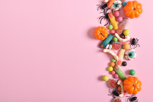 Various sweets on a pink background Happy Halloween Copy space Flat lay top view