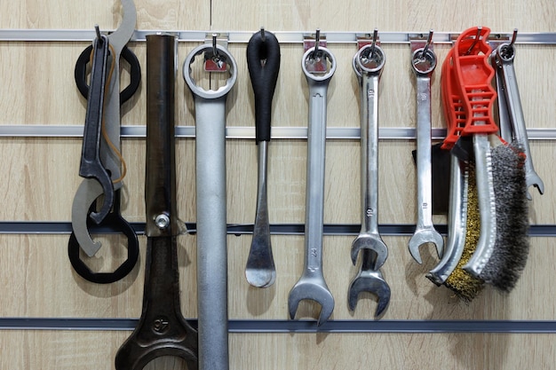 Various tools hang on the wooden wall in the workshop Motorcycle repair