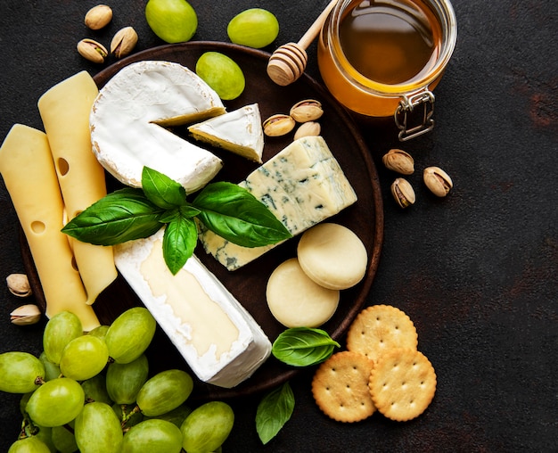 Photo various types of cheese  on a black concrete surface