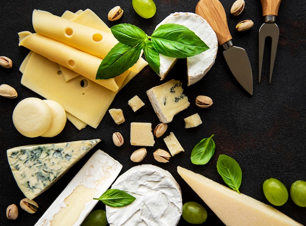 Various types of cheese on a black concrete surface