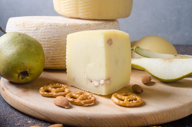 Various types of cheese heads and pieces on a wooden board