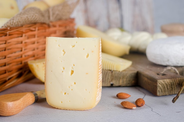 Various types of cheese heads and pieces on a wooden board