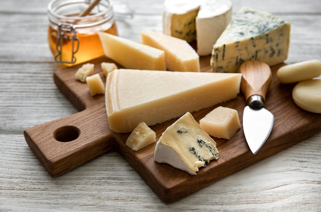 Various types of cheese on a white wooden background