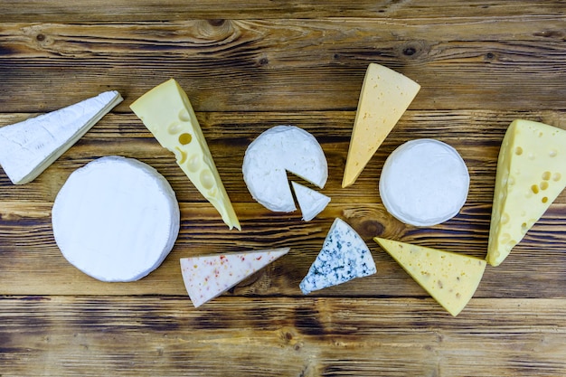 Photo various types of cheese on a wooden background top view