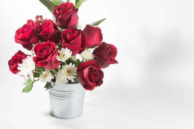 Vase of bouquet red Roses in aluminium bucket on white background.