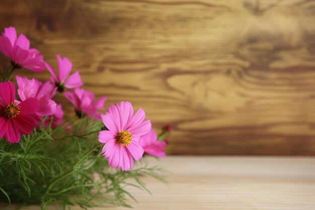 A vase of pink flowers on a wooden table